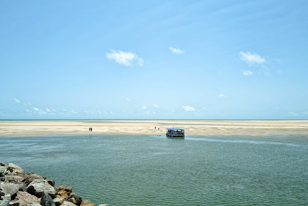 Embarcação de passeio diante de bancos de areia nas Fronhas Maranhenses em Raposa